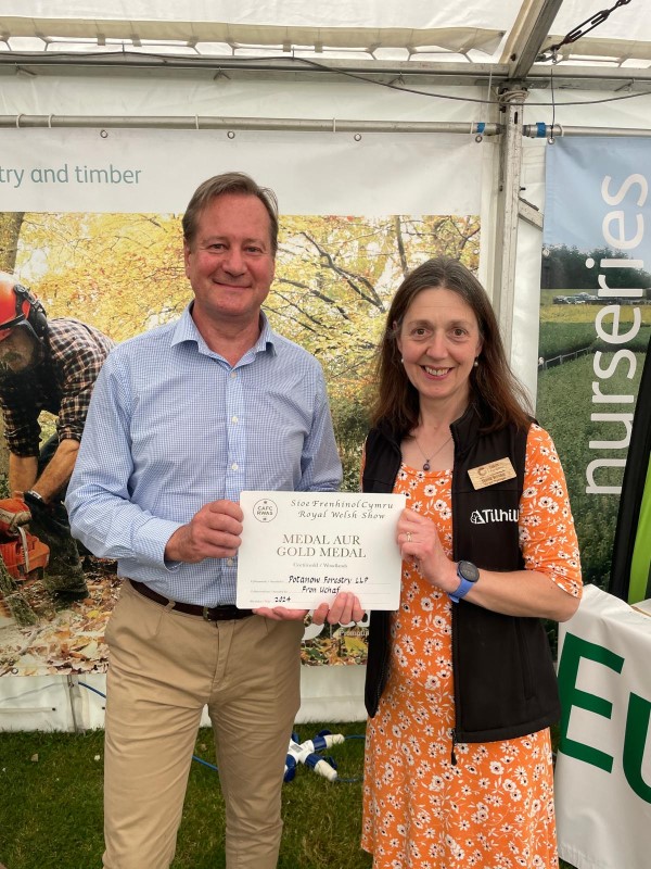 A man and a woman standing side by side holding a certificate.